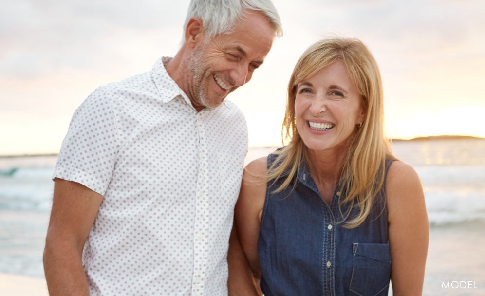 Older couple smiling on the beach